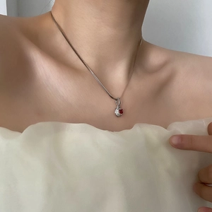 Elegant silver snake chain necklace with a red heart-shaped zircon pendant on a model