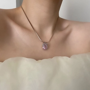 Collier avec pendentif animal en zircon rose et chaîne serpent élégante portée par un modèle