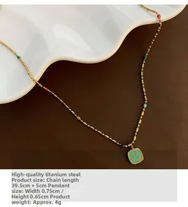 Dettaglio della collana in acciaio al titanio con perline e ciondolo smiley verde