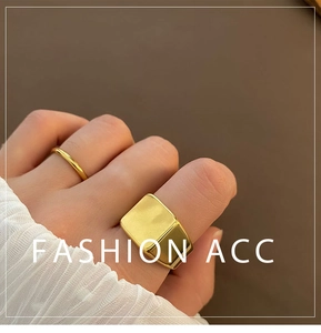 Close-up of a gold signet ring set and minimalist thin band worn on a finger