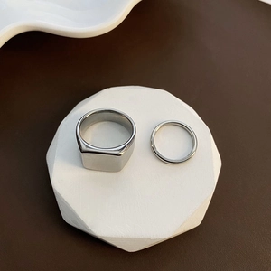 Minimalist silver square signet ring set for men and women on geometric display