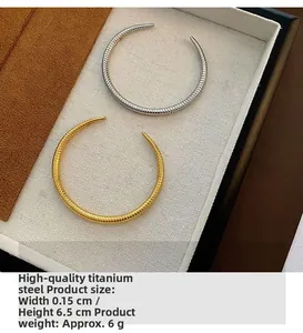 Detailed macro view of minimalist titanium steel open bangles in gold and silver finish