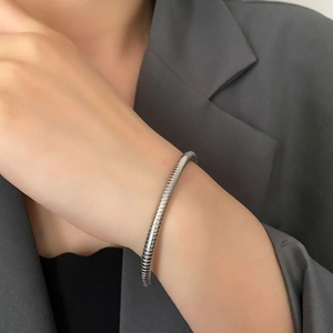 Minimalist silver snakeskin textured open bangle for women shown on a model's wrist
