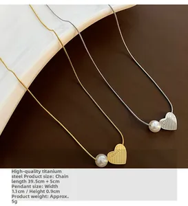 Detail of titanium steel heart pendant necklaces with textured surface and white pearl
