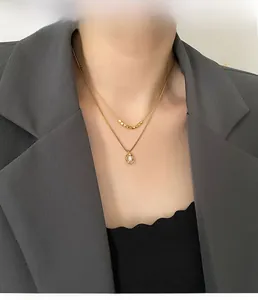 Collier double rang doré avec petites perles et pendentif perle baroque sur modèle