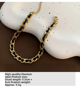 Detail of woven black rope and gold titanium steel chain bracelet with extension