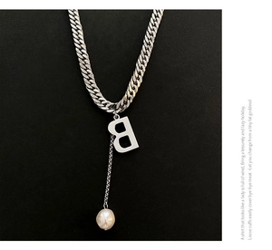 Detail einer silbernen Gliederkette mit B-Buchstaben-Anhänger und eleganter Perle