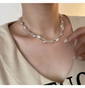 Détail macro d'un collier de perles d'eau douce multicouche avec chaîne en métal fin
