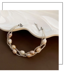 Gros plan détaillé d'un collier de perles multicouche avec fermoir mousqueton sur céramique