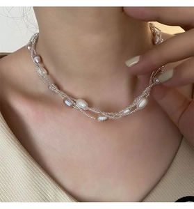 Gros plan d'un collier à trois rangs en perles d'eau douce avec un éclat élégant
