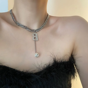 Silberne Gliederkette mit B-Anhänger und Perlenquaste am Dekolleté des Models getragen