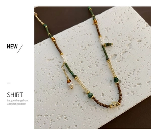 Macro detail of retro handmade beaded necklace with natural pearls and earth-tone beads