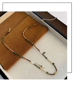 Detail of vintage beaded necklace with green beads and white freshwater pearls on display