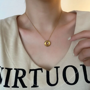 Minimalist gold twisted torus pendant necklace on O-chain for women worn by a model