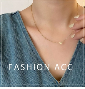 Détail d'un collier avec pendentif cœur en or minimaliste porté sur la clavicule
