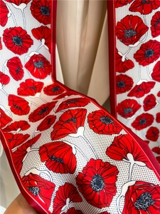 Détail d'un foulard en soie montrant des imprimés de coquelicots rouges vibrants