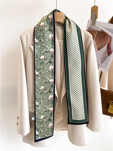 Détail d'un foulard en soie double face à fleurs et motifs sur un blazer beige