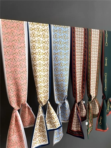 Detail view of colorful equestrian print silk scarves showing horse bits and chain patterns