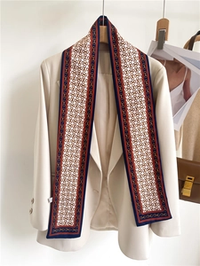 Classic horsebit print silk scarf styled as an accessory on a cream business blazer
