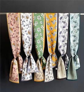 Detail of six colorful floral twilly scarves with hand-written summer-themed prints