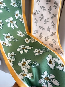 Close-up of dual-sided floral print silk scarves with vibrant yellow borders