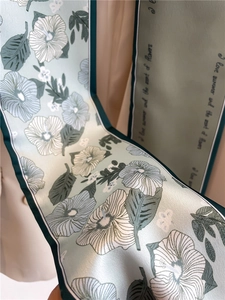 Detail of light green floral silk scarf with hibiscus print and summer quote text