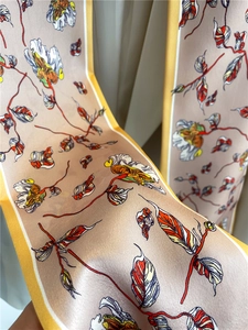 Macro shot of abstract floral print and champagne silk texture on the narrow scarf