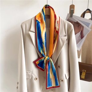Écharpe étroite en soie à imprimé abstrait nouée en nœud sur une veste de costume