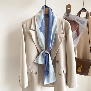 Foulard en soie bleu ciel imprimé paysage porté avec un blazer beige chic et moderne
