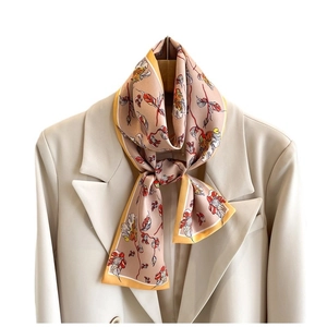 Floral print narrow silk scarf in dusty rose and yellow styled on a blazer collar