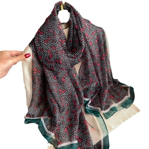 Floral print oversized faux silk scarf in black with red petals and dark green border