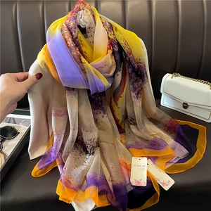 Elegant multi-color abstract print silk shawl with orange borders on a model