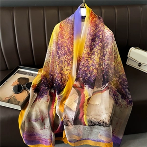 Artistic printed silk shawl with purple and orange gradient draped over a sofa