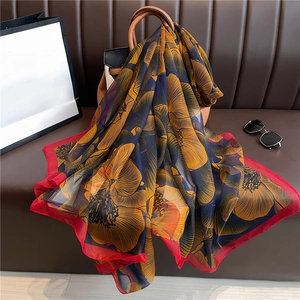 Luxurious large floral silk scarf with vibrant orange petals on a dark blue background