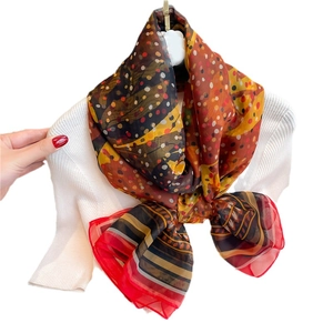 Large silk-like scarf with polka dots and geometric patterns on white knit top