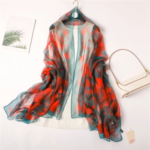 Floral print satin silk shawl featuring large red blossoms on dark green translucent fabric