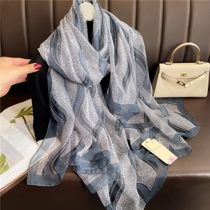 Detail view of wave pattern print on lightweight blue silk shawl with smooth texture