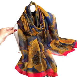 Elegant large silk scarf featuring bold yellow floral prints with red contrast borders