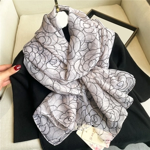 Detail of rose floral pattern on lightweight silk scarf with brand hanging tag