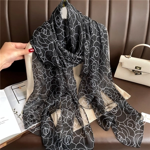 Detail of rose pattern scarf in black and white sheer fabric on an elegant clothes hanger
