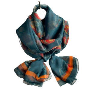 Elegant emerald green floral silk scarf with orange borders in a bow knot display