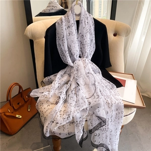 Detail of soft faux silk scarf featuring black crescent prints and delicate edge finish