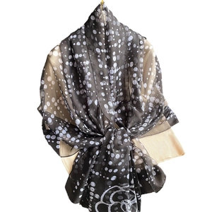 Polka dot silk scarf featuring a large camellia flower print on elegant black fabric