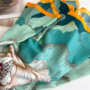 Close-up of silk scarf with artistic floral prints and fine rolled edges texture