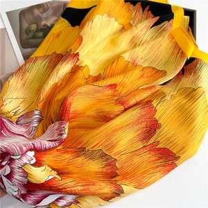 Satin floral silk scarf with vibrant orange yellow blooms and detailed twill texture
