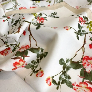 Close-up of silk scarf featuring rose floral pattern and twill texture details