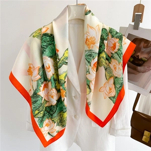 90cm silk scarf with lotus print and orange borders draped over a white blazer