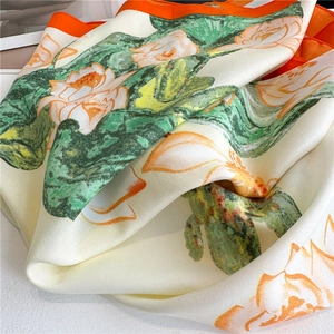 Detailed texture of silk lotus pattern scarf with orange hand-rolled stitched edges