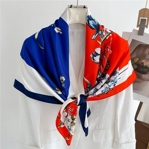 Floral print silk scarf with royal blue and red color blocks styled on white blazer