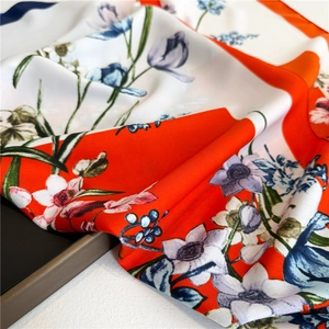 Detailed view of floral silk scarf featuring elegant blue lilies and smooth satin texture